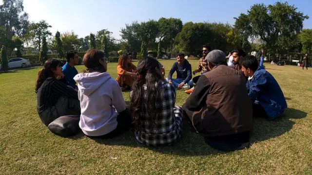 A group of students sit in a circle