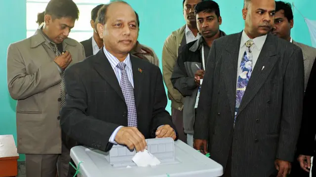 ২০০৮ সালে সেনাপ্রধানের দায়িত্বে থাকা মঈন উ আহমেদ ভোট ব্যালট বাক্সে ফেলছেন, পাশে দাঁড়িয়ে আছেন কয়েকজন ব্যক্তি