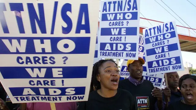 Centenasativistas anti-Aids da Aids Therapeutic Treatment Now (ATTN) marcham para protestar contra a inacção do governo sul-africanofornecer medicamentos antirretrovirais a pessoas infectadas com o vírus HIV, 3Agosto2003Durban.