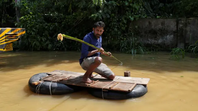 Mężczyzna korzysta z prowizorycznej tratwy na zalanym obszarze, po przejściu cyklonu Ditwah w Kelaniya na Sri Lance