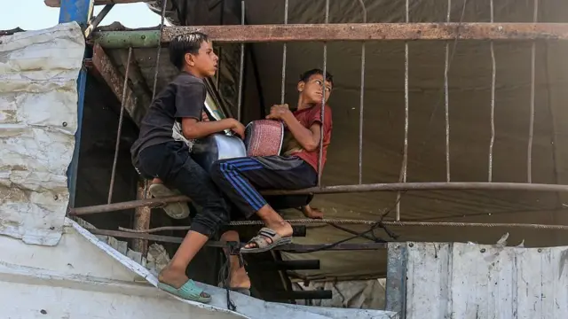 أطفال فلسطينيون يتلقون الغذاء الذي توزعه منظمات الإغاثة
