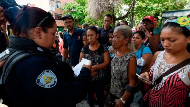 Una policía dando información a los familiares de los presos.