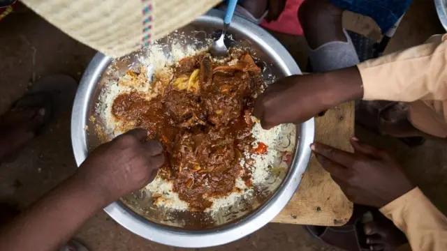 Une famille malienne autour du repas, le 21 août 2018, à Bamako, le jour de la fête musulmane de l'Eid al-Adha.