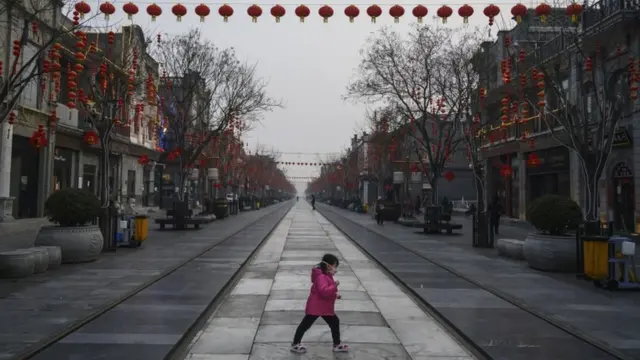 Meninacomo ganhar bônus na pixbetmáscara no rosto atravessa rua vazia na China