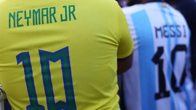 Duas pessoas com as costas das camisascentral esporte apostaNeymar ecentral esporte apostaMessi por suas seleções