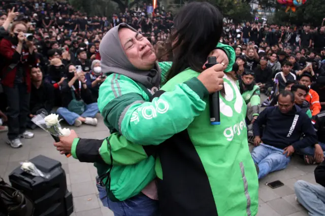 Pengemudi ojek daring menangis dan berpelukan usai berorasi saat saat Aksi Solidaritas di Alun-alun Kota Malang, Jawa Timur, Jumat (29/8/2025). 