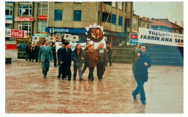 Özelleştirme sürecinde kentte düzenlenen eylemlerden biri. Taşınan pankartta, "Yozgatlı uyuma, fabrikana sahip çık" yazıyor. Eylemcilerin elinde bir çelenk var. 