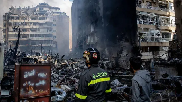 Люди наблюдают за горящим зданием после авиаудара Израиля 8 апреля 2026 года в Бейруте, Ливан.