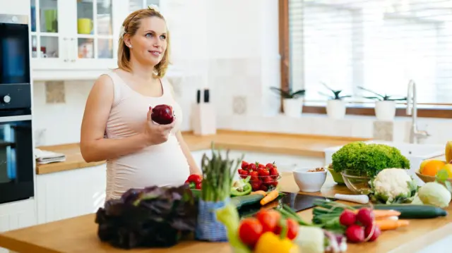 Mujer embarazada preparando comida saludable 