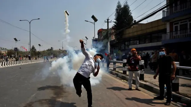 तीनकुनेमा प्रहरीले प्रहार गरेको अश्रुग्यासको गोला टिपेर प्रहरीतिर नै फ्याँक्दै एक प्रदर्शनकारी