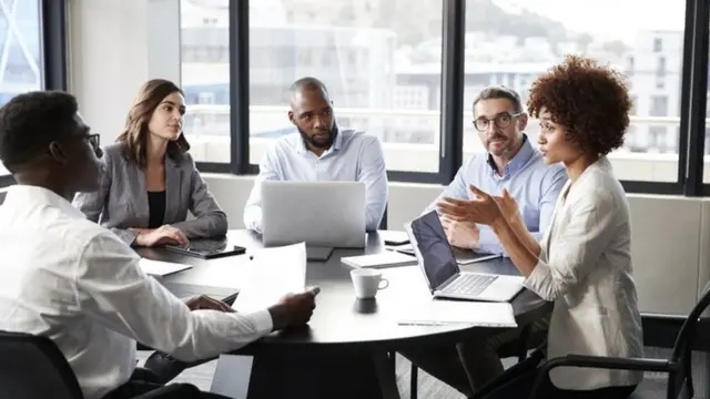 Une femme s'adresse à des collègues lors d'une réunion d'affaires.
