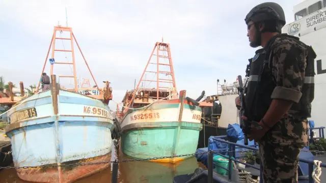 Seorang petugas Kapal Pengawas Kementerian Kelautan dan Perikanan bersiaga di sekitar kapal pencuri ikan berbendera Vietnam di Sungai Rengas, Kalimantan Barat, Kamis (09/01)