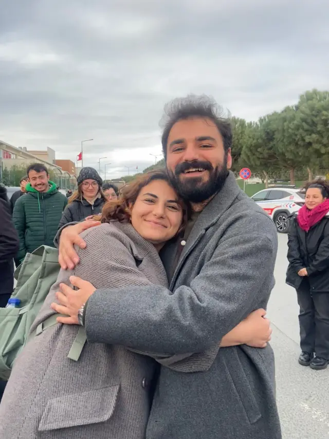 Ezgi ve Berkant Tatlı kardeşler gülümseyerek birbirine sarılıyor.