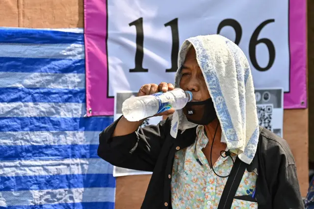 ผู้ไปใช้สิทธิเลือกตั้งดื่มน้ำอย่างกระหาย ท่ามกลางอากาศร้อนจัดใน กทม.