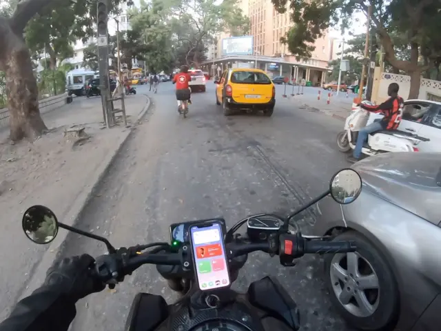 Derrière son casque le motard anonyme sensibilise les usagers et sauve des vies humaines sur les routes de Dakar.