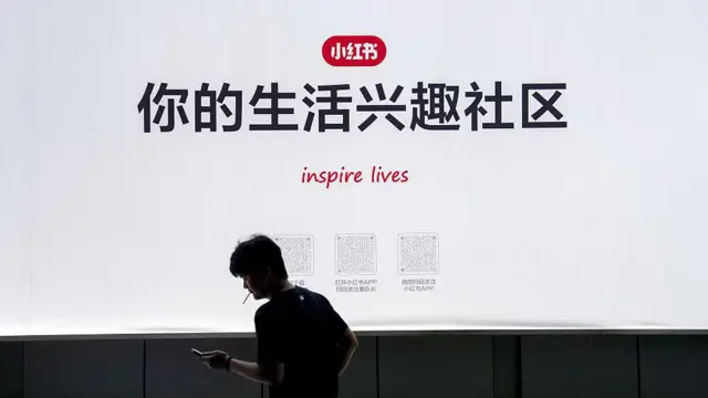 2025年9月15日,小红书在上海总部的标示牌,写有“你的生活兴趣社区”的字眼,一名男子在标示牌前抽烟。
