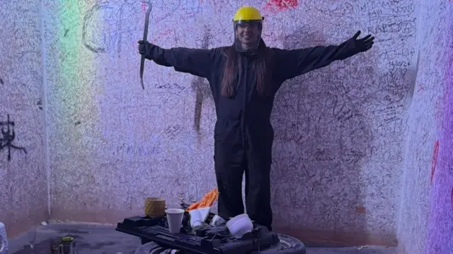 تصویر زنی در اتاق خشم که لباس محافظ پوشیده است