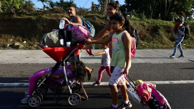 pais e crianças caminhando com malas