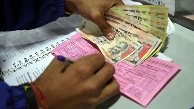 बैंक में नकद जमा करता आदमी