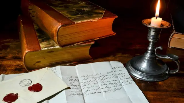 Libros, velas y documentos antiguos.