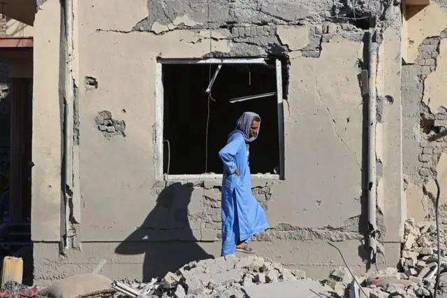 یکی از ساکنان روستایی در ولسوالی سمکنی پکتیا در کنار بقایای ساختمانی که در پی حمله هوایی دیشب پاکستان تخریب شده است، ۲۹ ژوئن ۲۰۲۶