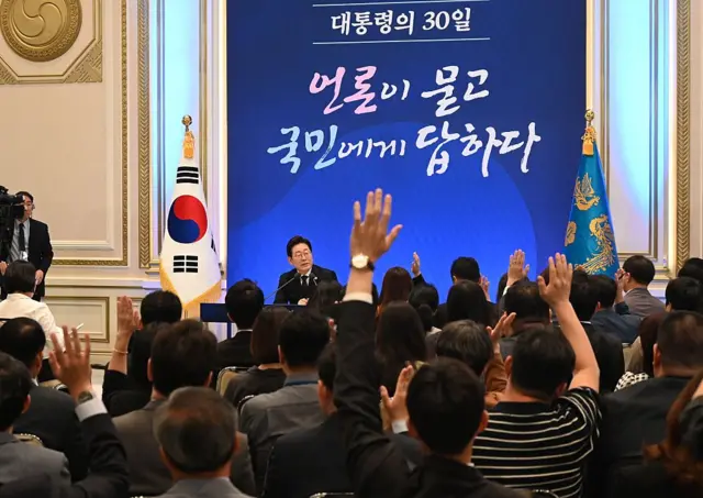 취재진들이 이재명 대통령에게 질의를 하기 위해 손을 들고 있다