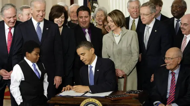 Barack Obama firmando Obamacare.