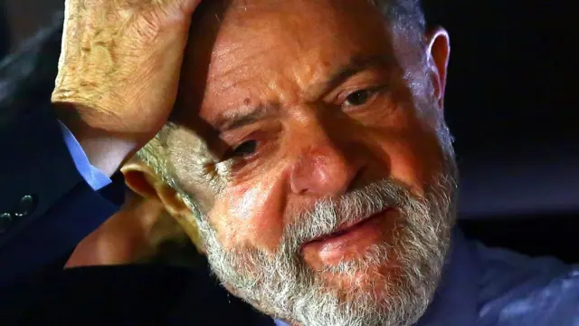 Lula sorri, olha para baixo e coloca a mão na cabeçadono da luva betfotodono da luva betarquivo