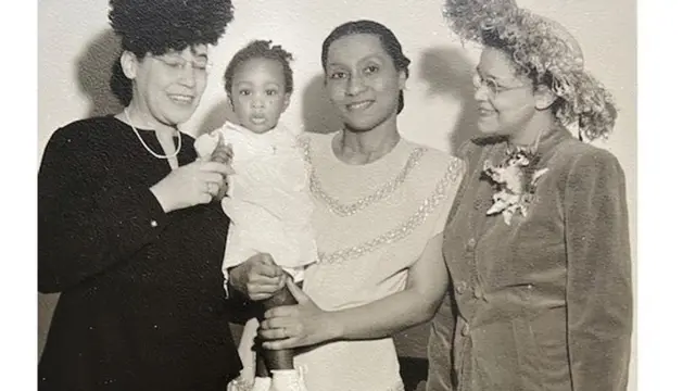 Dickens tient dans ses bras sa fille Jayne, avec son mentor Virginia Alexander (à gauche) et son amie Sadie Alexander (à droite)