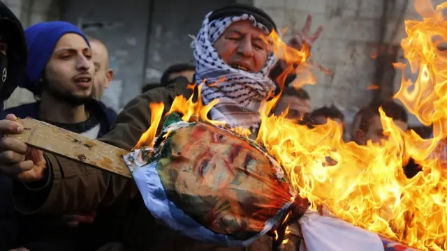 Palestinian protesters burn an effigy of Donald Trump in Nablus, West Bank, on 7 December 2017