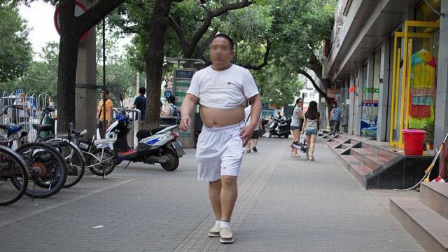 热浪袭来，很多中国中年男子掀起上衣纳凉已成为习惯。