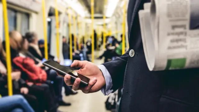 comprobando el teléfono en el metro