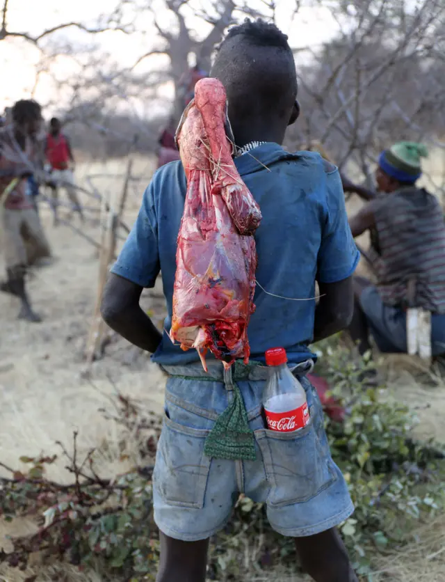 Menino hadza com um pedaçogonzalo garcia pelayo roulettecarne crua e uma coca-cola