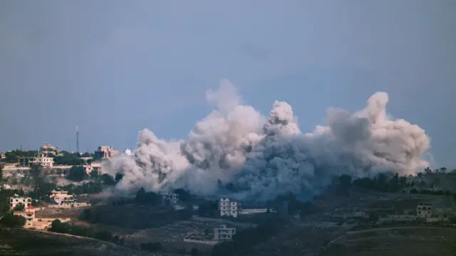 صورة تظهر سحباً كثيفة من الدخان تتصاعد من بين المنازل على إثر غارة إسرائيلية في جنوبي لبنان