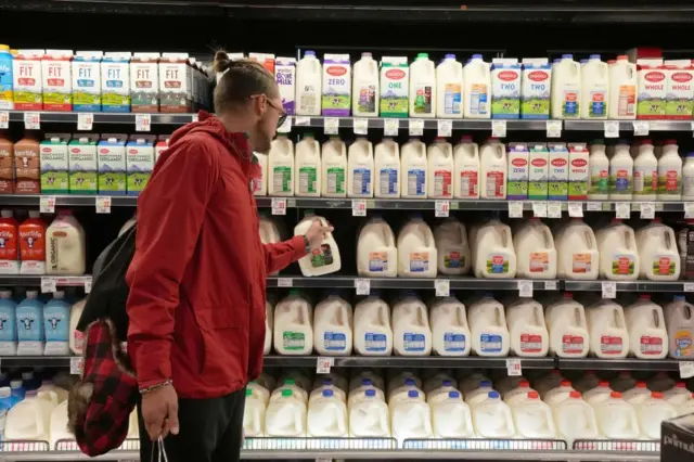 डिपार्टमेंटल स्टोर में दूध लेता एक विदेशी युवक