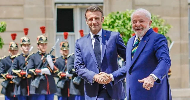 Lula e Macron apertando mãos com guardas da república francesa ao fundomollybetcerimônia oficial