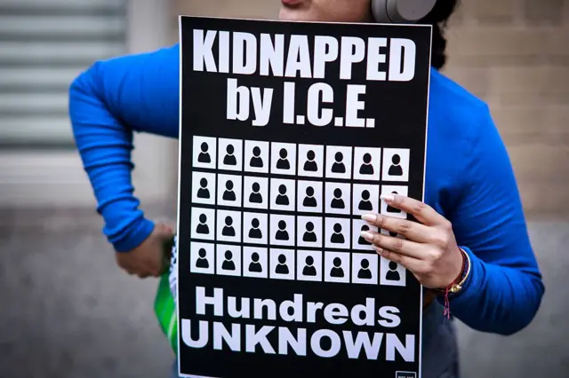 Mujer con un cartel que dice "Secuestrados por ICE"