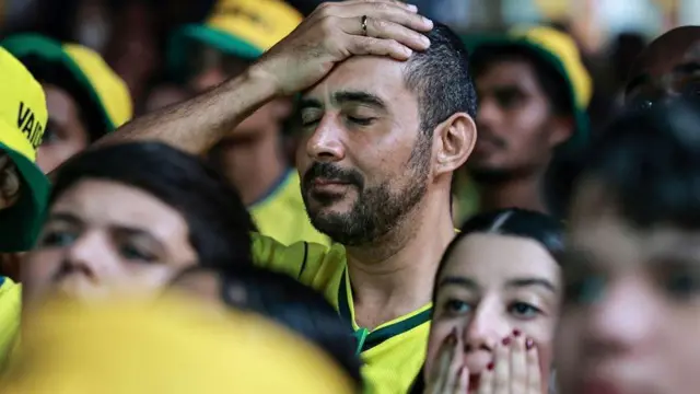 Torcedor leva mão à cabeça durante jogo Brasil x Noruega