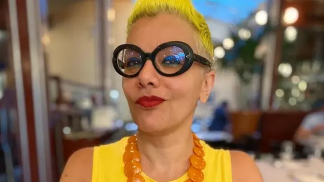 Mona Eltahawy, cheveux jaunes coupés et lunettes épaisses