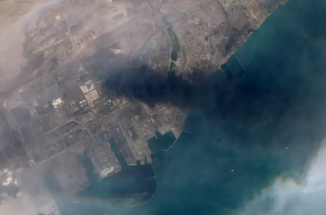 صورة من القمر الاصطناعي تُظهر تصاعد الدخان من جراء الانفجار الذي وقع في ميناء الشهيد رجائي، بندر عباس، إيران، في 27 أبريل/نيسان 2025.