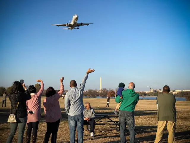 날아가는 항공기를 향해 손을 흔드는 사람들