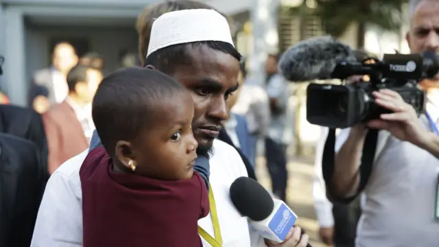 A Rohingya man and child wait to meet the Pope in Dhaka