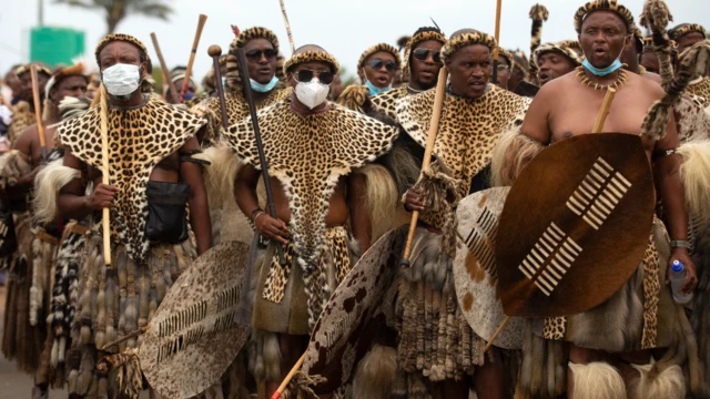 Zulu men wear traditional warrior outfits at night for Nongoma, South Africa - March 2021