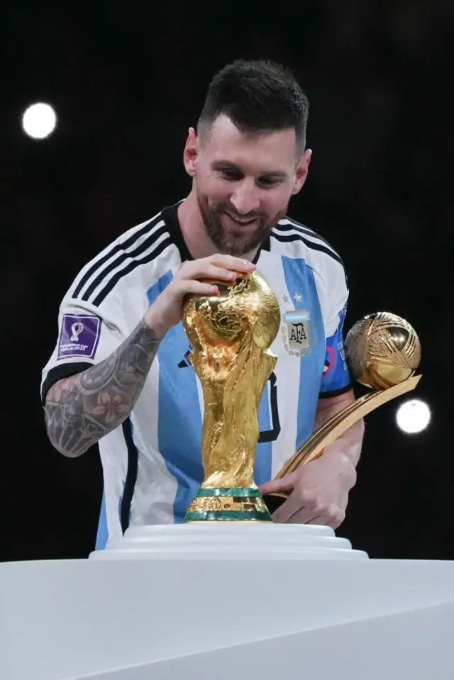 Lionel Messi acariciando o troféu da Copa do Mundo após a final da Copa de 2022, no Catar