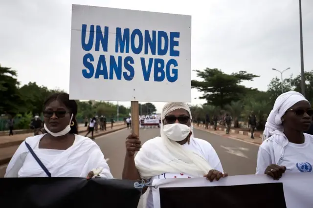 Une femme tient une pancarte sur laquelle on peut lire « Un monde sans VBG (violences basées sur le genre) » à Bamako le samedi 26, 2020, lors d'une manifestation contre les violences faites aux femmes au Mali, quelques jours après l'arrestation du célèbre joueur de kora Sidiki Diabate pour le battement et l'enlèvement présumés de sa petite amie.