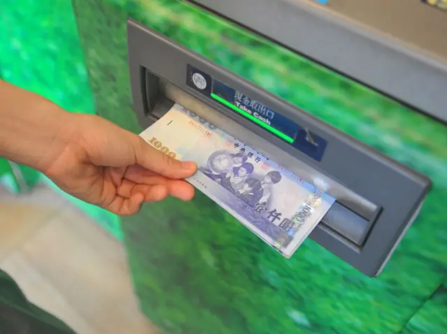 一名台湾民众正在领取现金。