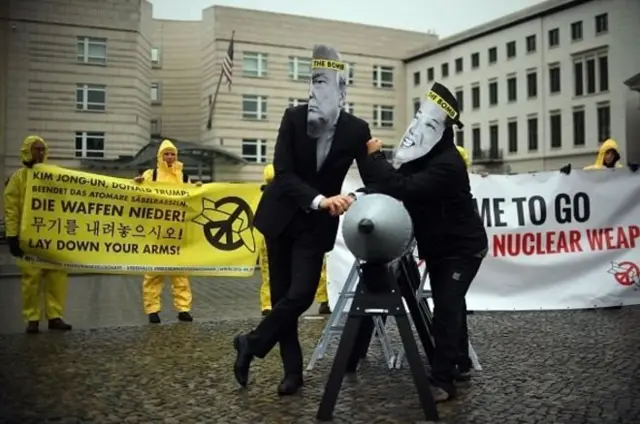 นักเคลื่อนไหวกลุ่มไอแคน สวมหน้ากากประธานาธิบดีโดนัลด์ ทรัมป์ ของสหรัฐฯ และนายคิม จอง อึน ผู้นำสูงสุดของเกาหลีเหนือ ระหว่างการทำกิจกรรมต่อต้านอาวุธนิวเคลียร์ที่หน้าสถานทูตเกาหลีเหนือในกรุงเบอร์ลินของเยอรมนีเมื่อวันที่ 13 ก.ย. ที่ผ่านมา