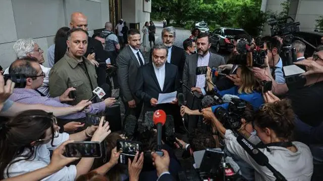 Arakçi basın mensuplarıyla çevrelenmiş ve açıklama yapıyor. 