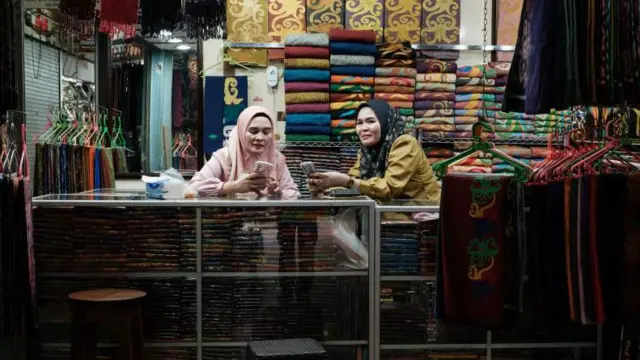 Dua penjaga toko kain menunggu calon pembeli di Pasar Inpres Kebun Sayur, Balikpapan, Kalimantan Timur, pada Juli 2024. 