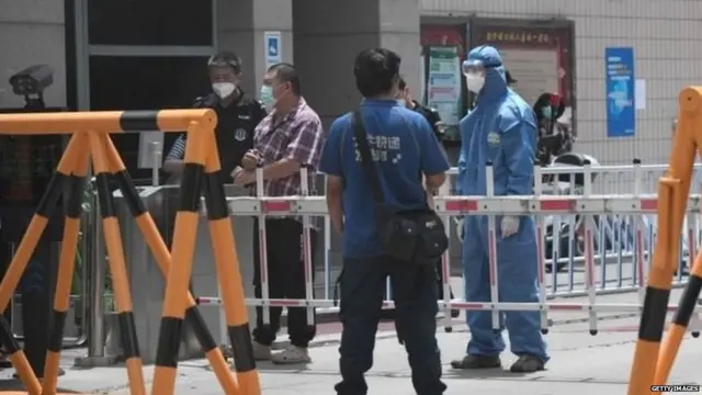 Security guards at a residential area under restrictions near Yuquan East Market in Beijing